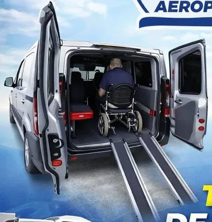 Pasajero en silla de ruedas dentro de la van, subido por la rampa